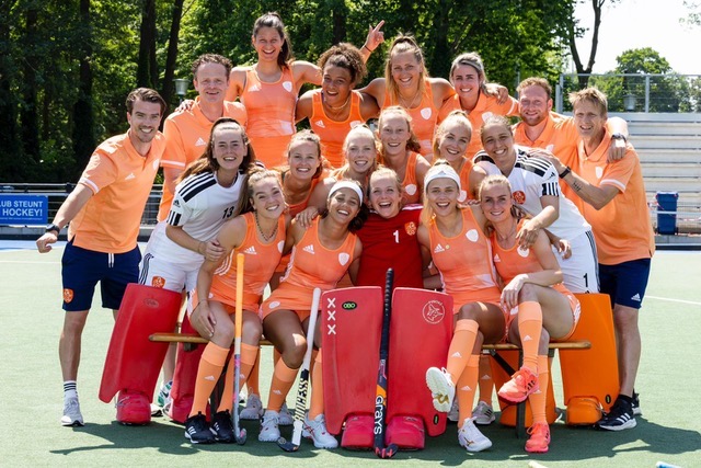 Teamfoto van een selectie met staf op het hockeyveld
